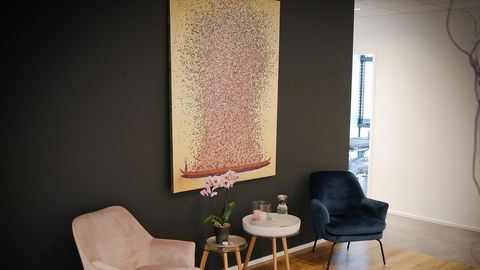 Wartebereich mit Sesseln, Orchidee und großem Gemälde