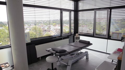 Heller Behandlungsraum mit großer Fensterfront und Blick über Zirndorf